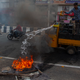 Police clear road blocks as a man tries to douse a fire set by protestors in Gauhati, India on Dec. 12.